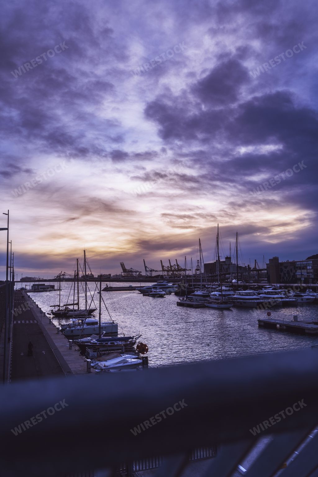 A beautiful sunset over the port of Barcelona. Some boats and the calm of the sea are appreciated.