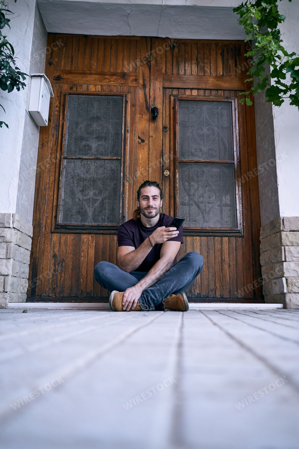 A vertical shot of a Caucasian man chatting with his smartphone