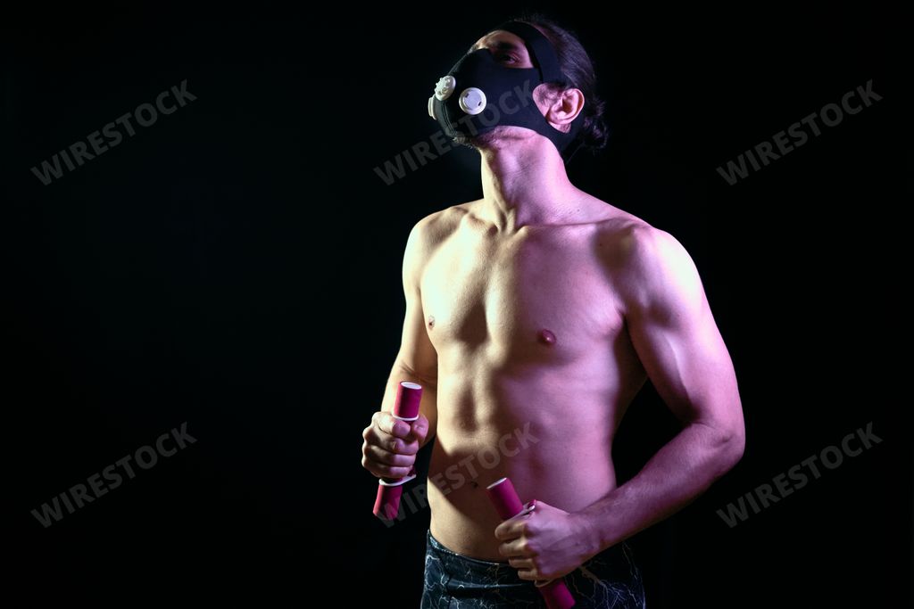 A fit young male training alone despite coronavirus pandemic at home using a training mask