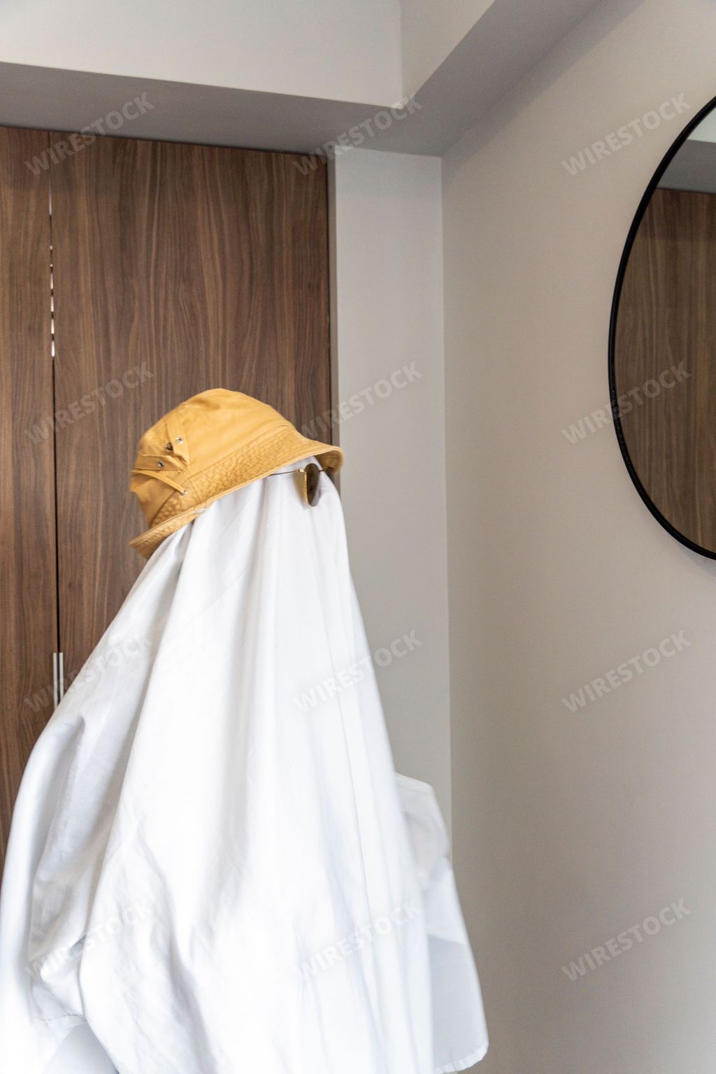 A person wearing a hat and black-rimmed sunglasses over a white cloth resembling a ghost