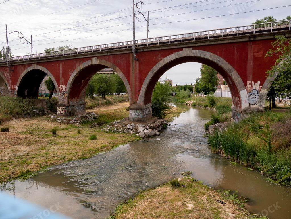 A scenic view of an old bridge over a small creek in Spain