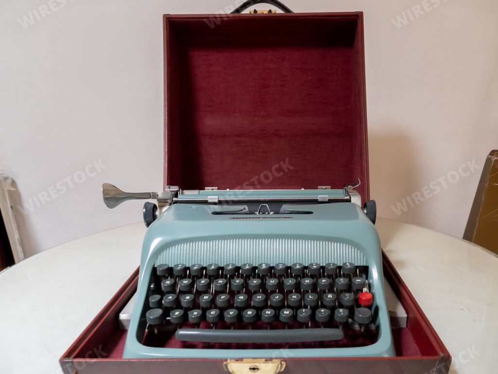 An old blue typing machine in a red box
