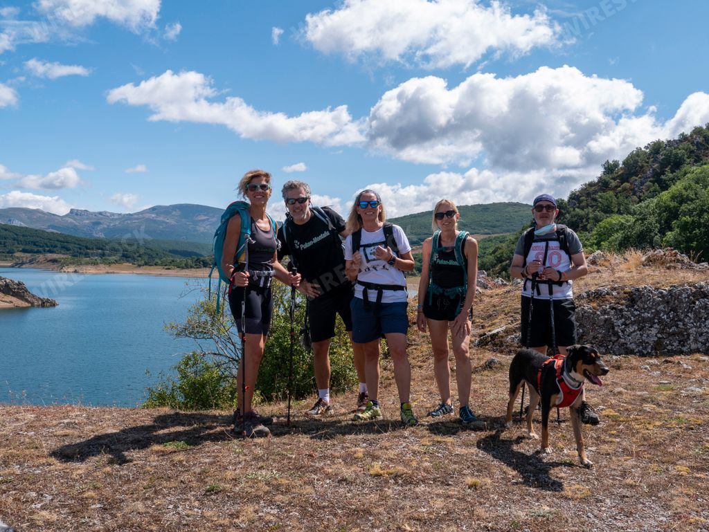 A group of Caucasian backpackers against a scenic lake
