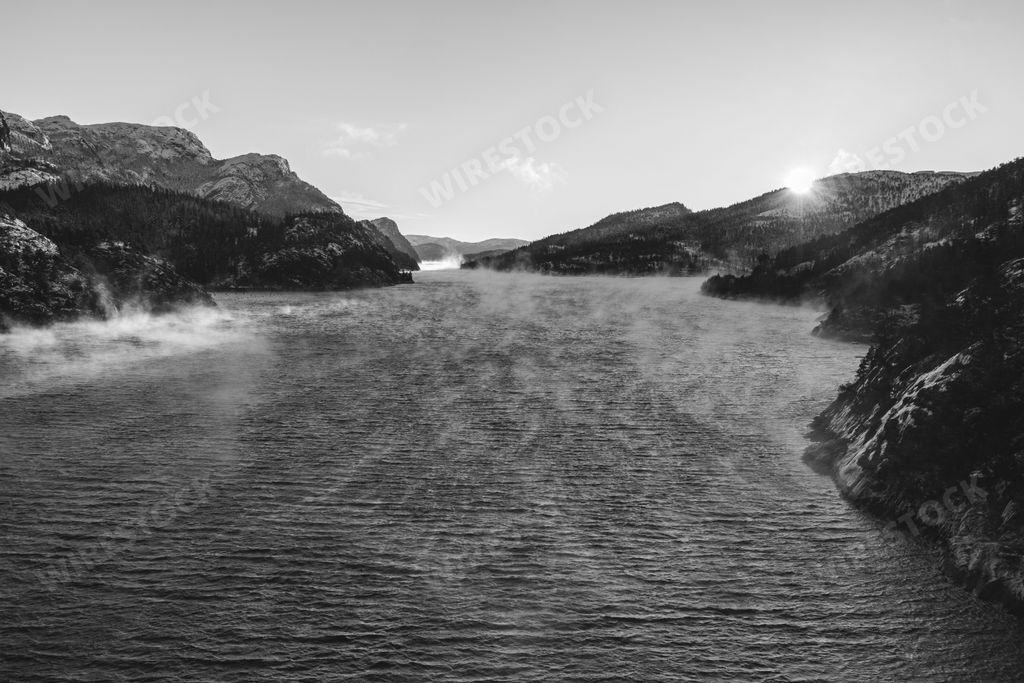 An idyllic black-and-white landscape of a mountain river in grayscale