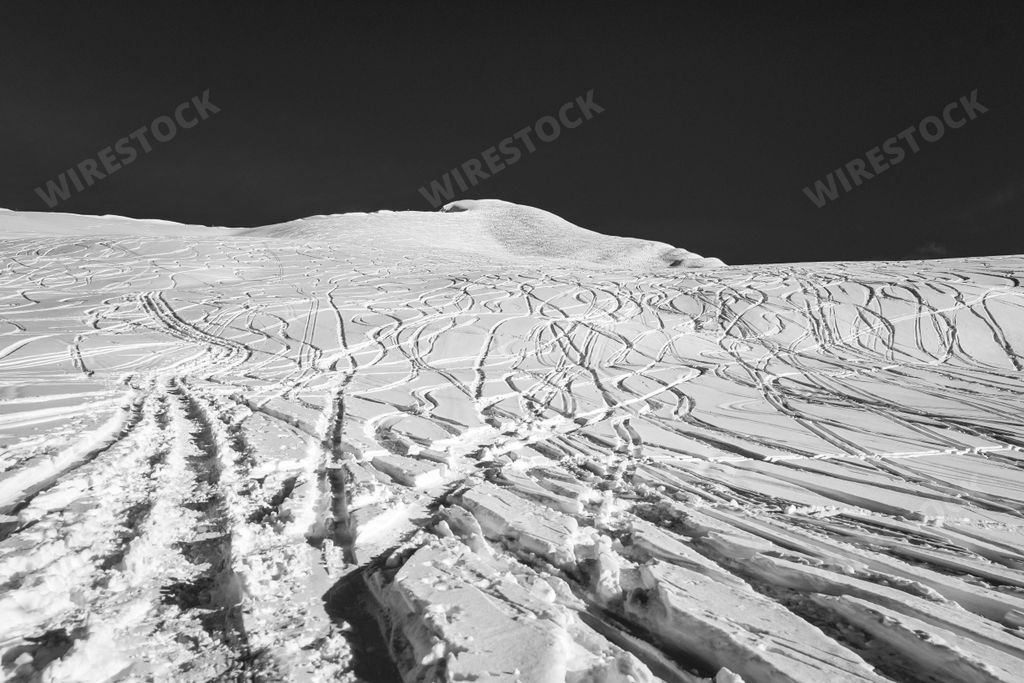 A minimalistic beautiful grayscale background of a snowy hillside with car trails