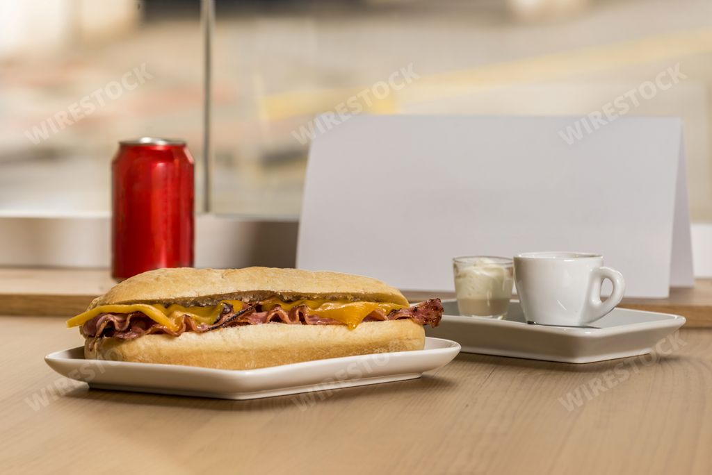 The bacon and cheese sandwich with coffee and soda in a can
