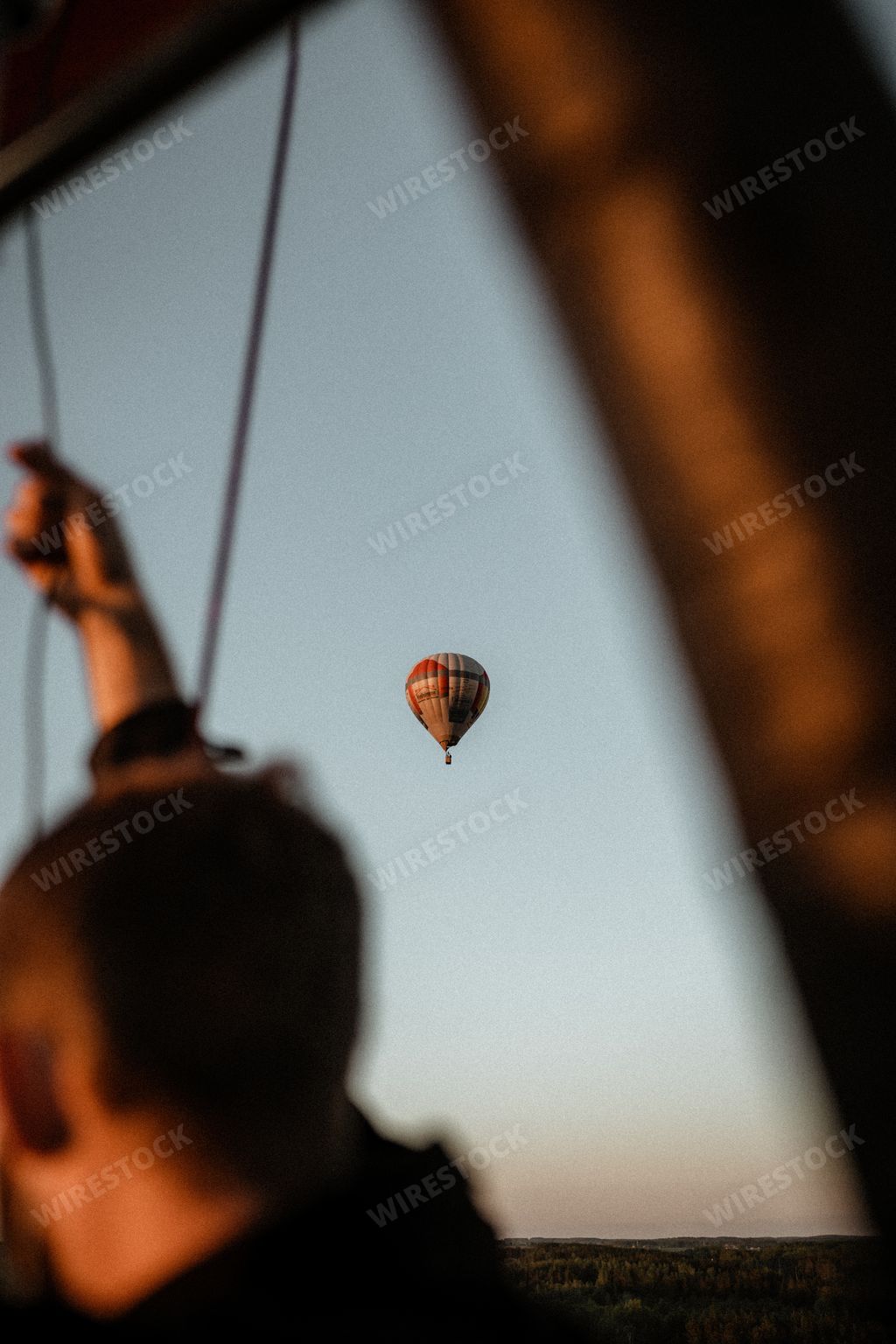 A vertical low angle shot of a hot air balloon in the sky captured from a boat