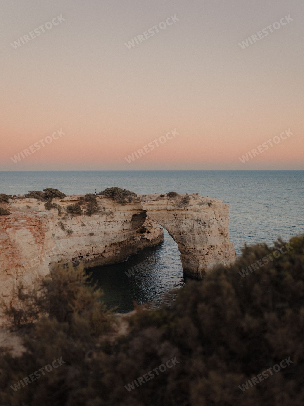 A beautiful view of the Arco De Albandeira, Algarve, Portugal at sunset, vertical shot