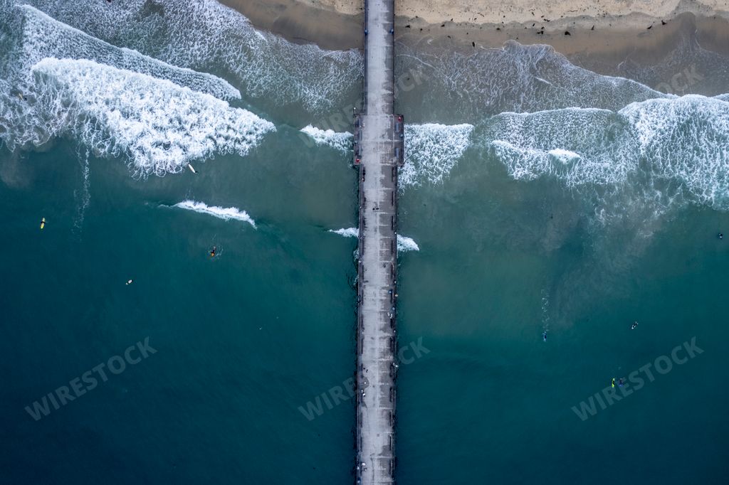 The beautiful view of the pier and blue ocean waves from a drone.