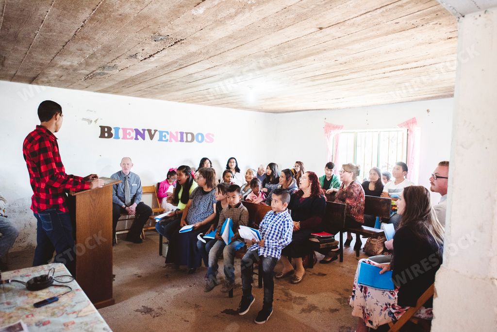 A group of religious people praying together in a small Mexican village church