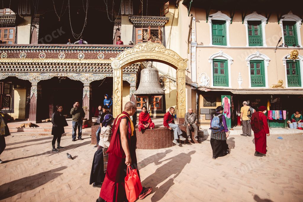A closeup shot of an old man with traditional clothes of worship of Buddhism in Nepal in the street