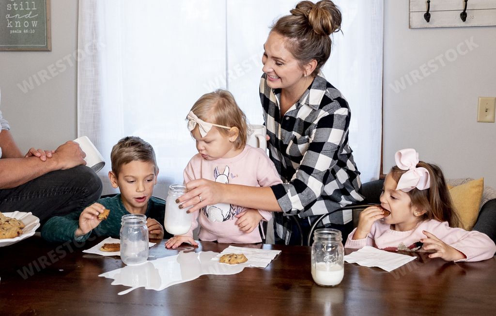 A closeup shot of a happy family eating chocolate chips and drinking milk - family concept