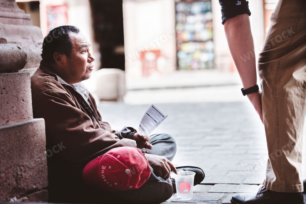 A shallow focus of a Hispanic beggar on the side of the road begging for money and food in Zacatecas, Mexico