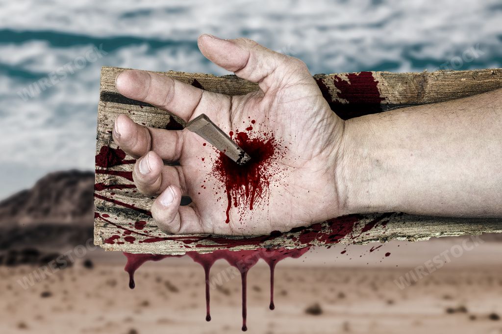 A closeup of Jesus Christ's hand nailed to a wooden cross