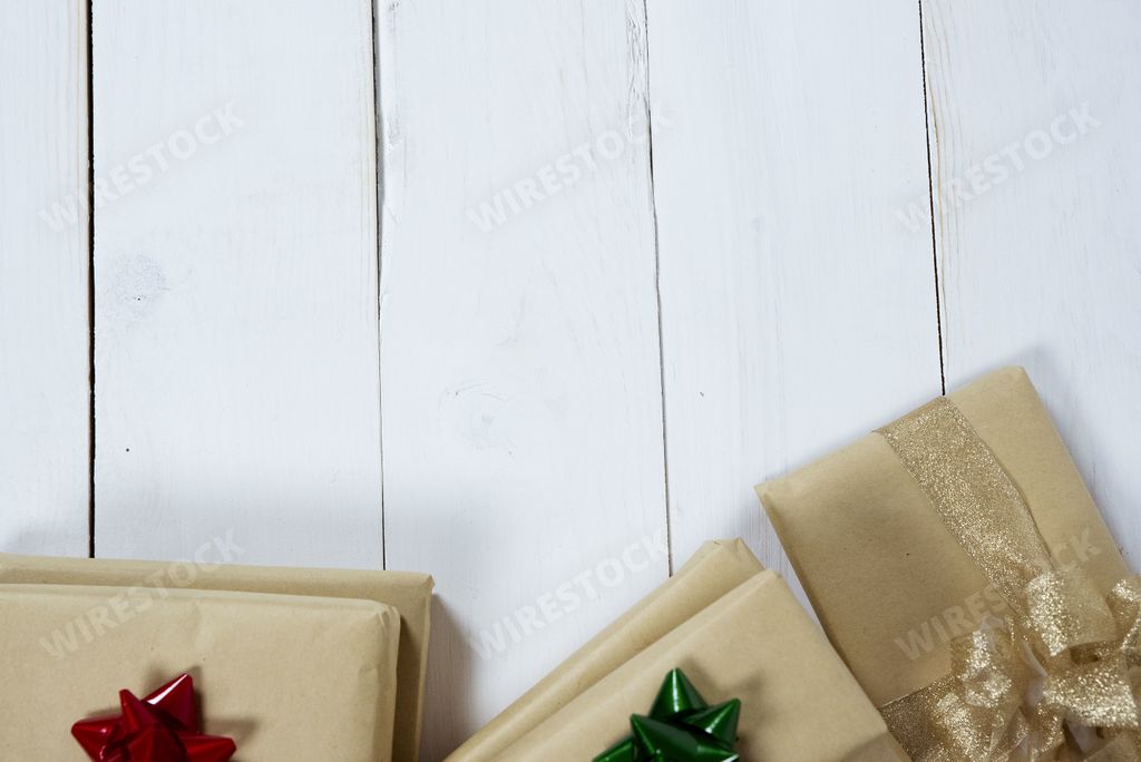 An overhead shot of a white wooden surface with presents on the bottom great for writing text