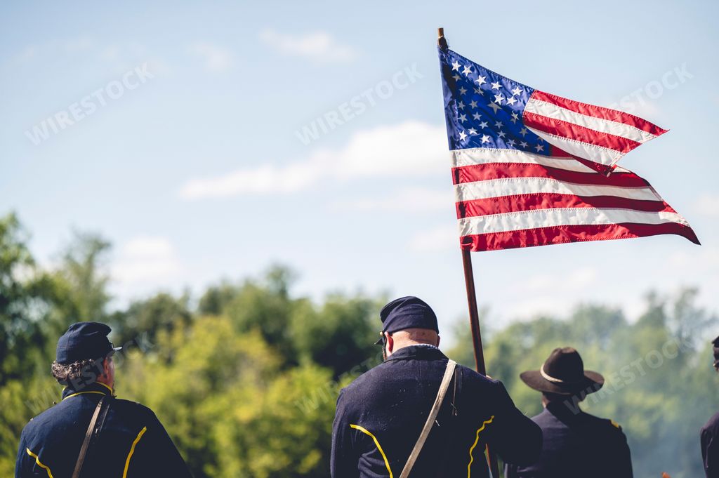 A soldier holding the flag of America during military performance in the Civil war reenactment in Jackson city, Michigan, USA