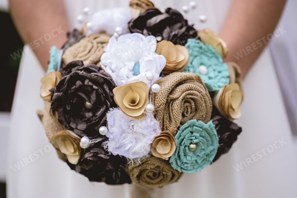 A closeup shot of the bride holding a bouquet of flowers with a blurred background
