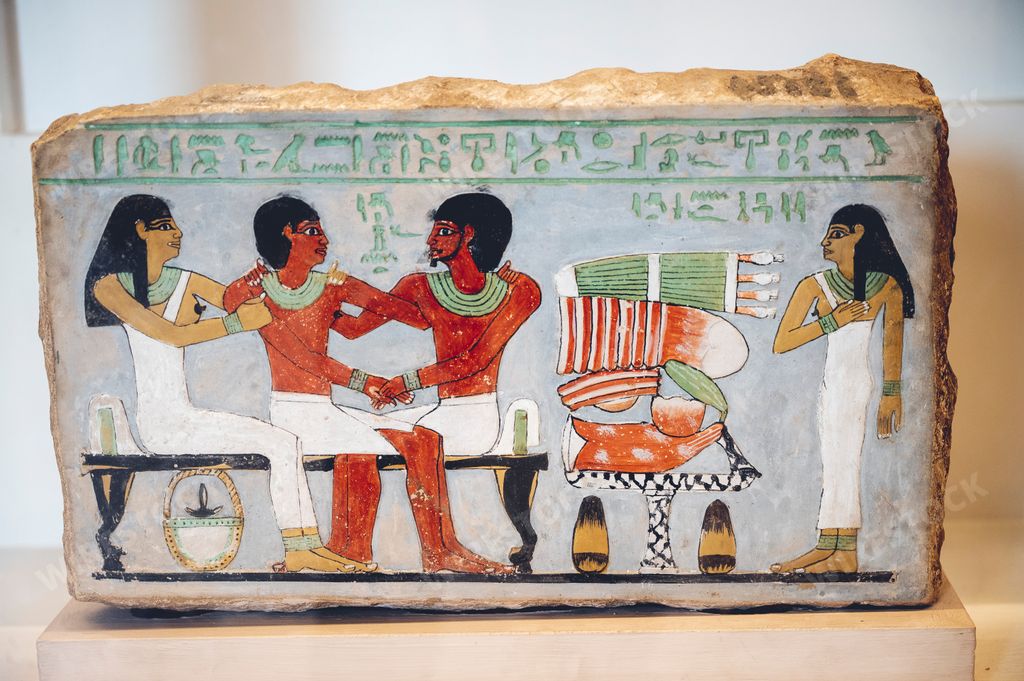 An ancient Egyptian slab of stone with hieroglyphs and peasants depicted on it in the Egyptian Museum in Cairo