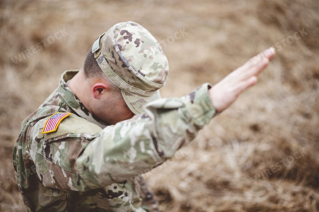 A selective focus shot of an American soldier with his hand raised above