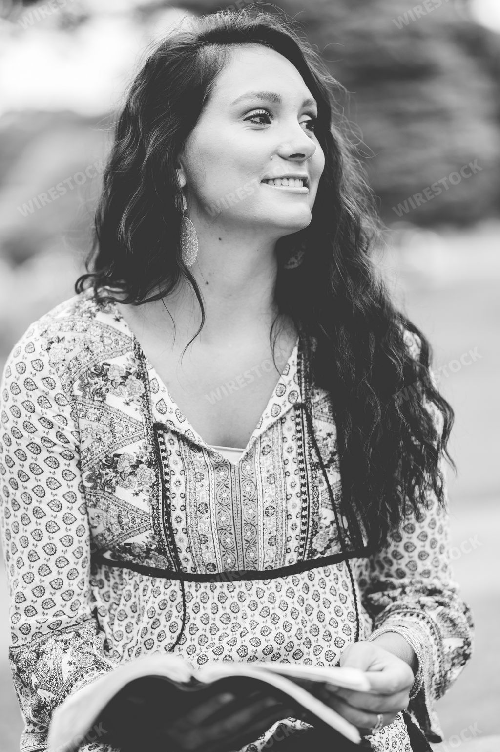 A grayscale portrait of a beautiful American lady with a book