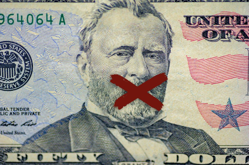 A closeup shot of the Ulysses s. grant face on the dollar bill with an x painted on his mouth