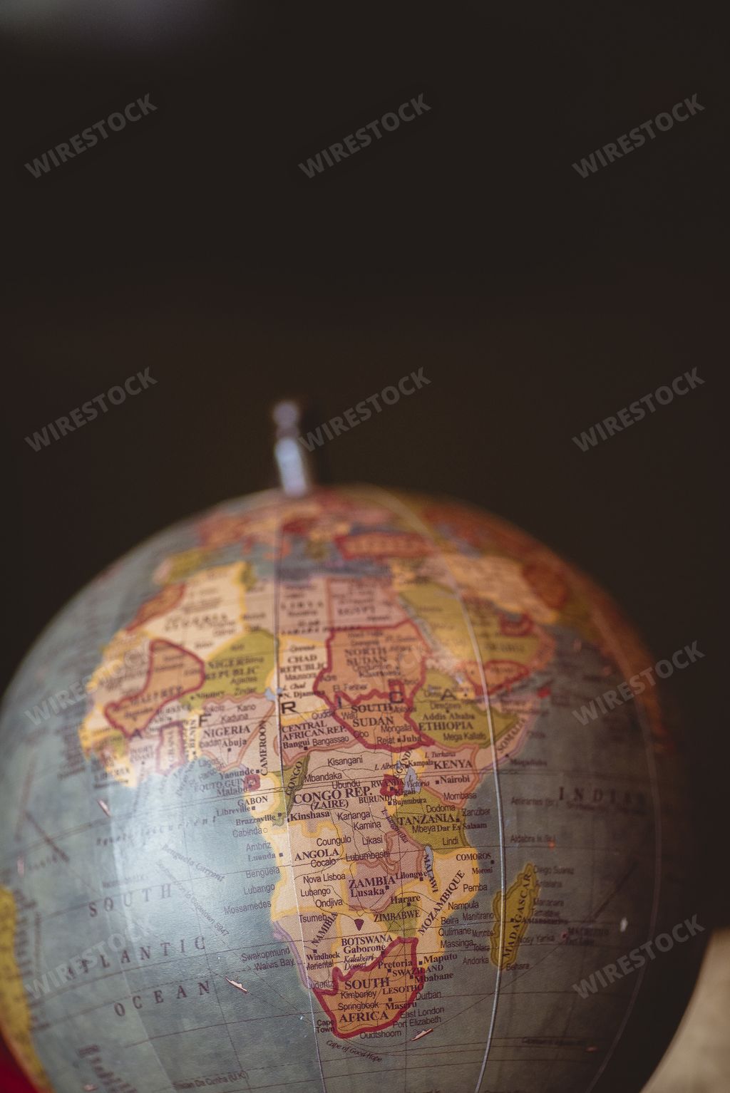 A vertical closeup shot of countries on the desk globe with a blurred background
