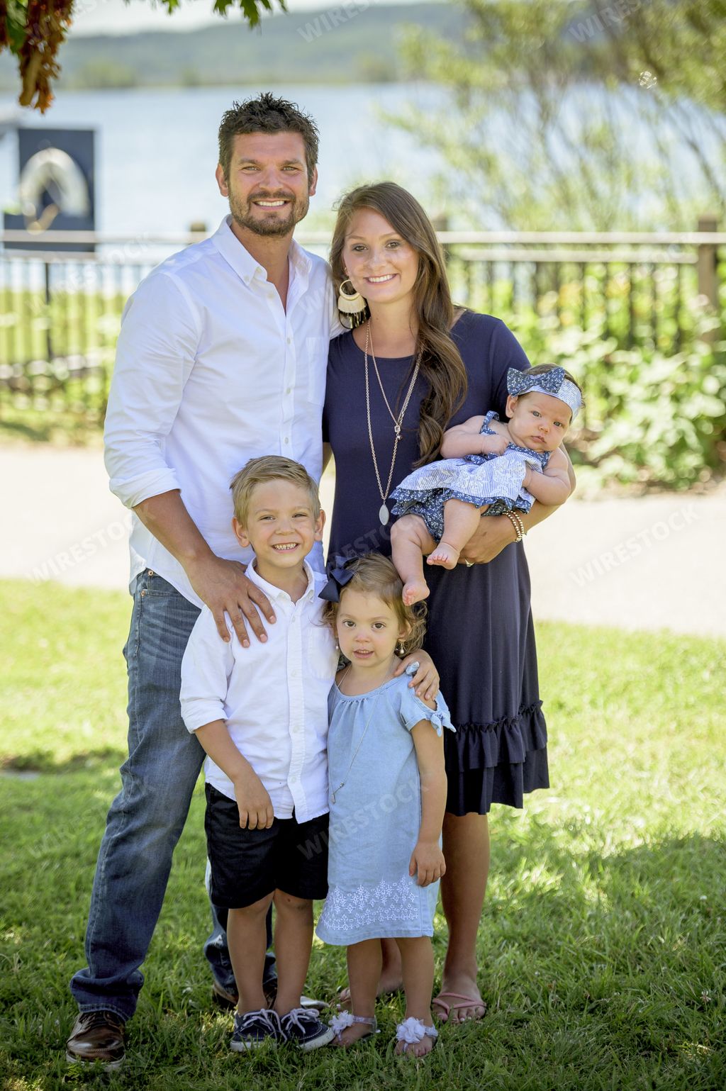 A vertical shot of a happy family with three children with a blurred background