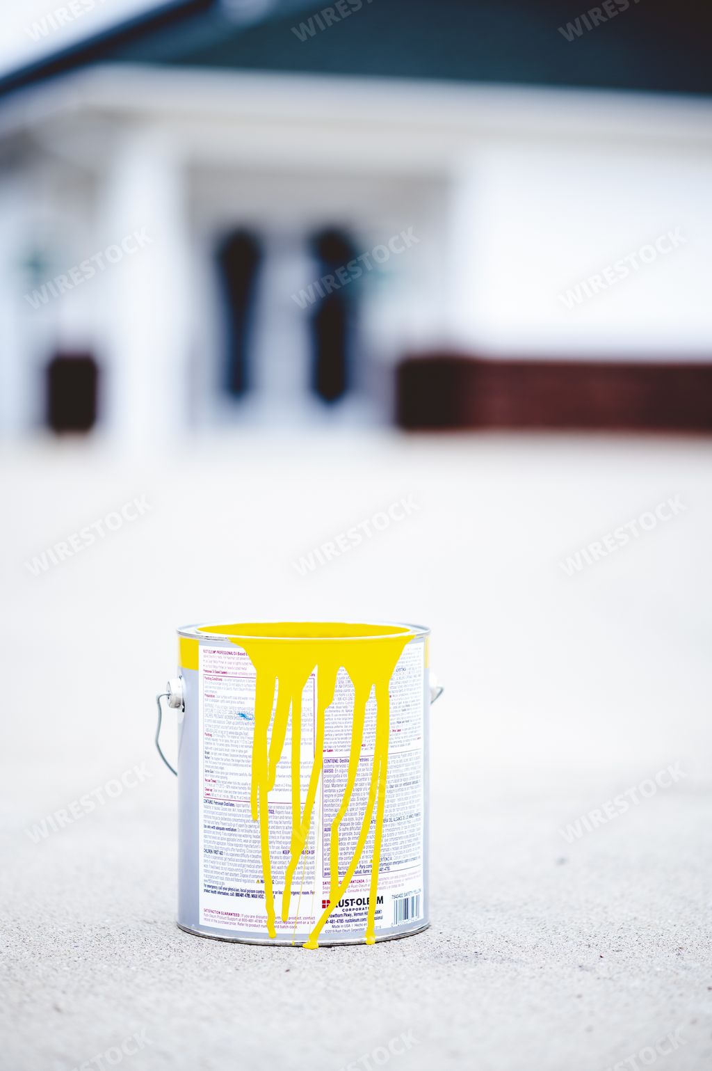 A can of yellow paint of a concrete ground
