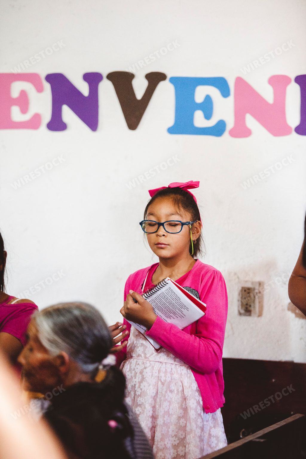 A young Mexican girl holding a prayer book in a small Mexican village church