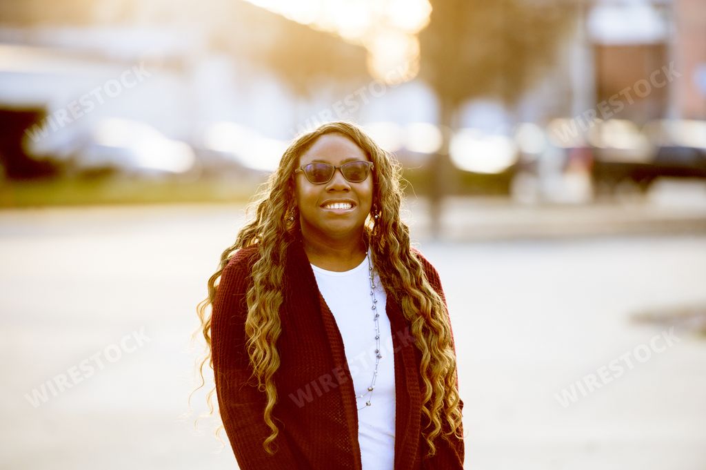 An attractive African American female wearing glasses smiling at the camera