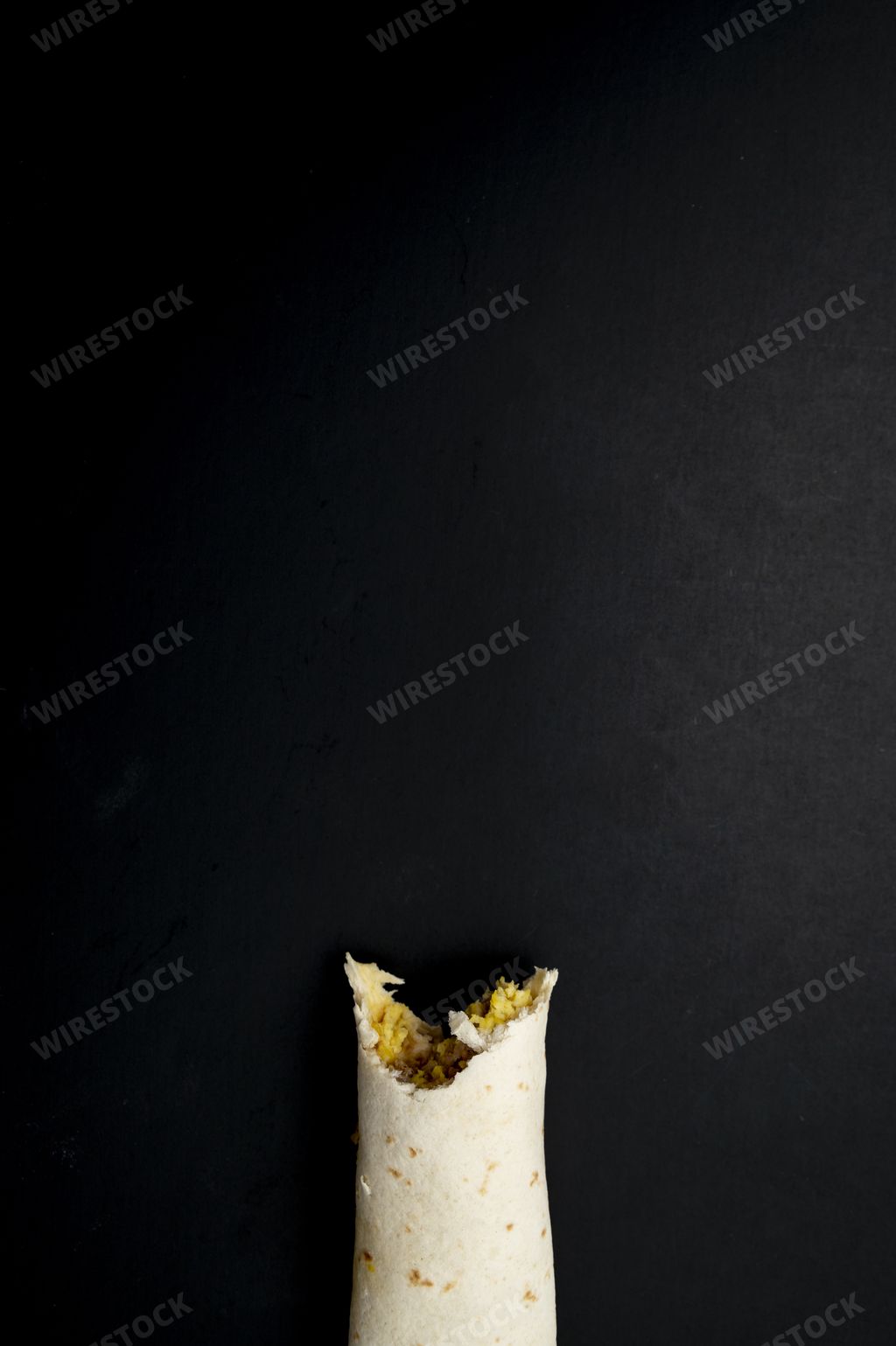 A top view of tortilla roll in a black background