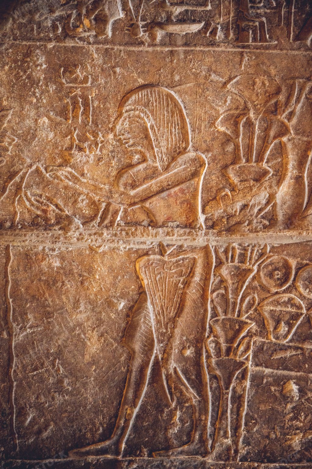 A vertical shot of an ancient slab of stone in the Egyptian Museum in Cairo depicting a woman making offerings to the gods