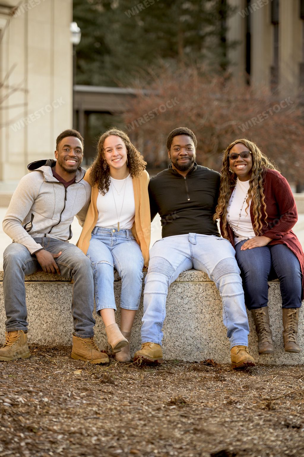 A group of people sitting in a park under sunlight with a blurry background