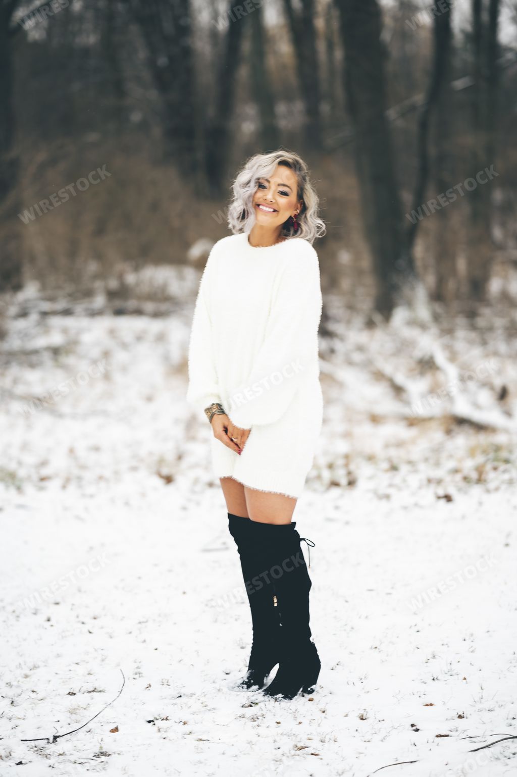 Sexy young female wearing a white sweater dress with black long boots Stock  photo | Wirestock