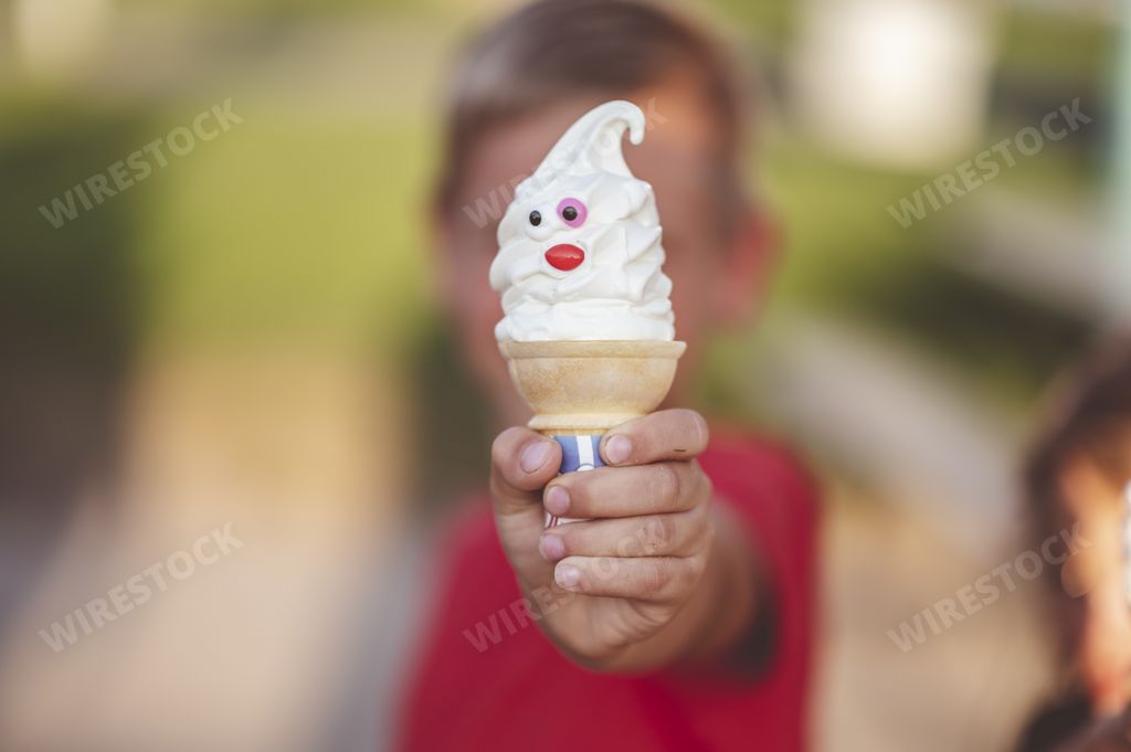 A closeup focus shot of a boy holding a cute ice cream