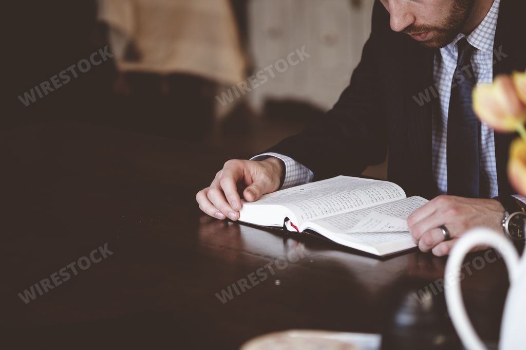 A shallow focus shot of a person reading an Arabic book with a blurred background