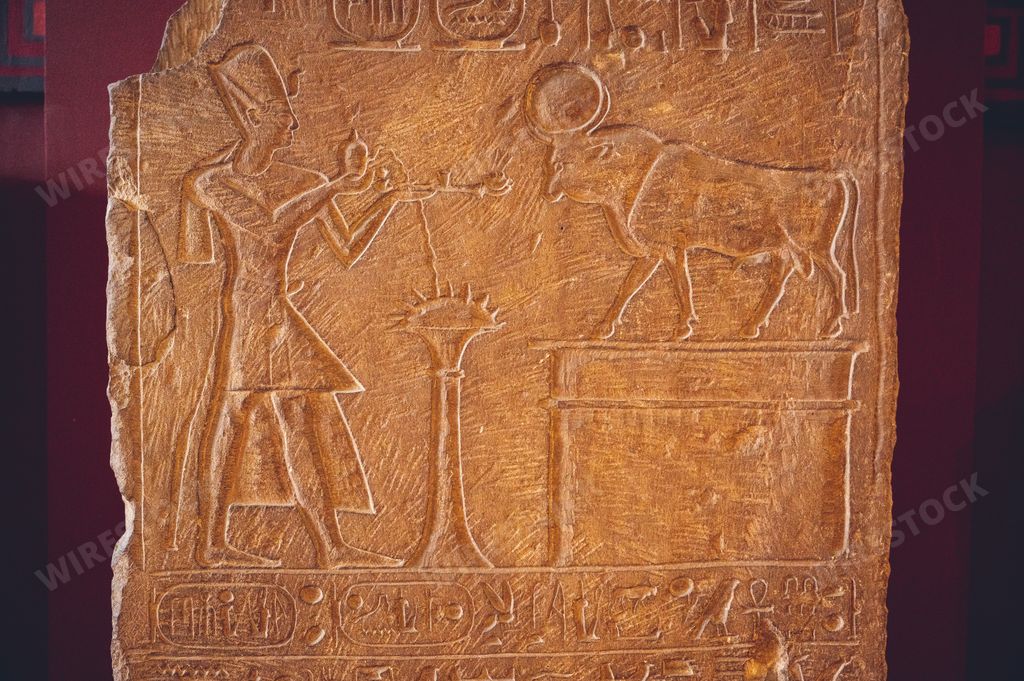 An ancient slab of stone in the Egyptian Museum in Cairo with a pharaoh making an offering to Api