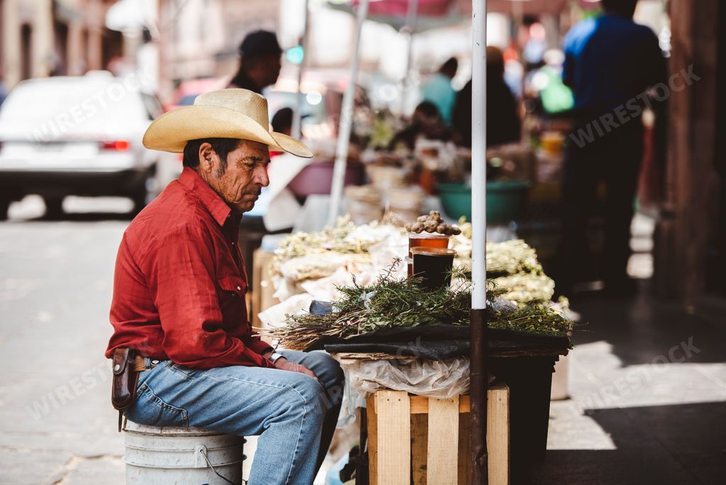 A male Hispanic vendor with a cowboy hat selling food at a market Zacatecas, Mexico