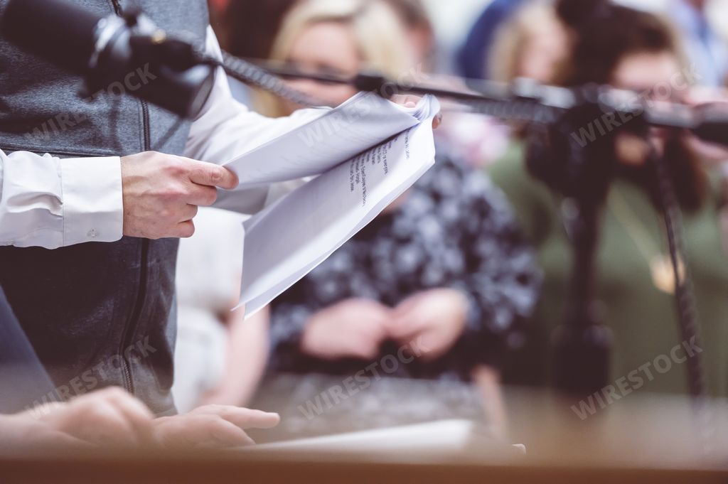 A closeup shot of a man's hand keeping a book on his hands near to the microphone