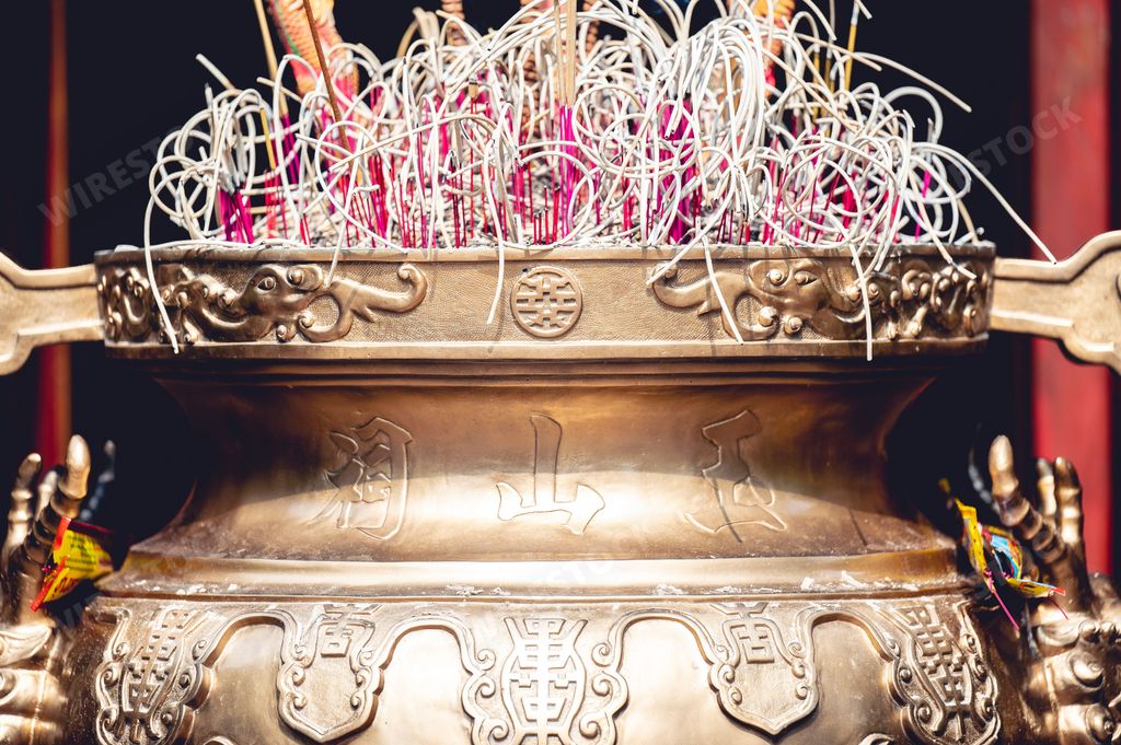 A closeup of the burning incense sticks in a large ceremonial  Buddhist temple urn in Vietnam