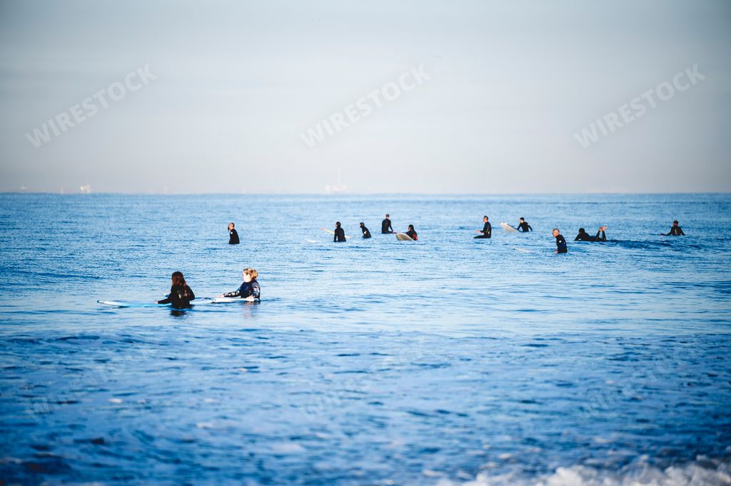 The surfers on the water's surface waiting for waves. Newport Beach, California.