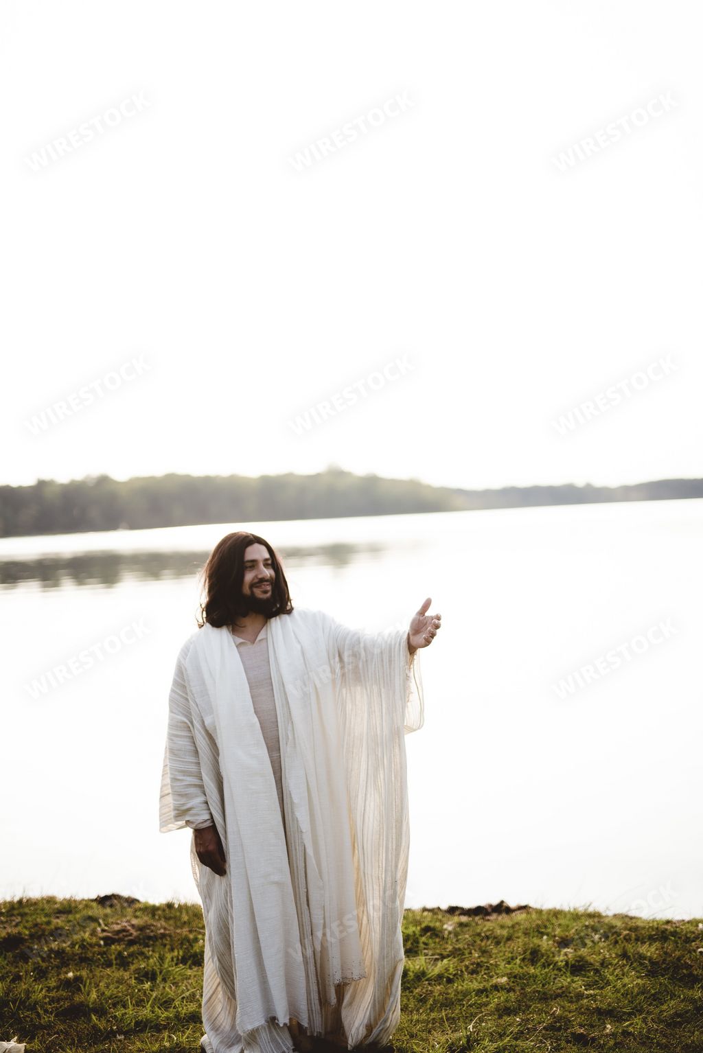 A vertical shot of Jesus Christ smiling and lending a hand for help