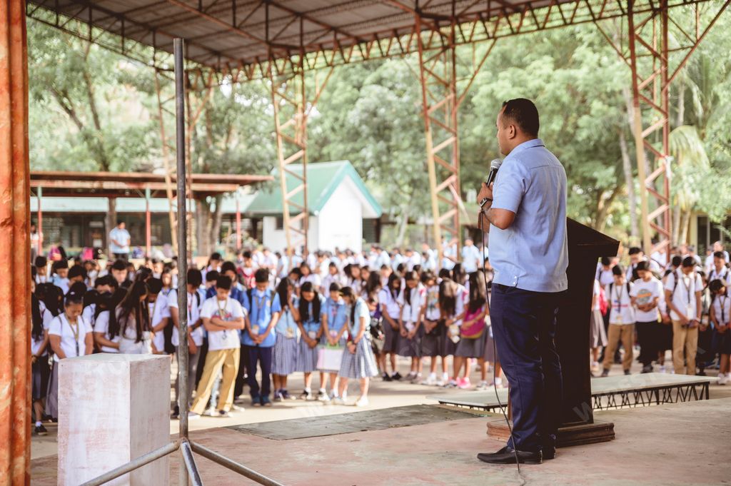 A group of Filipino high school students gathering for a corporate speech