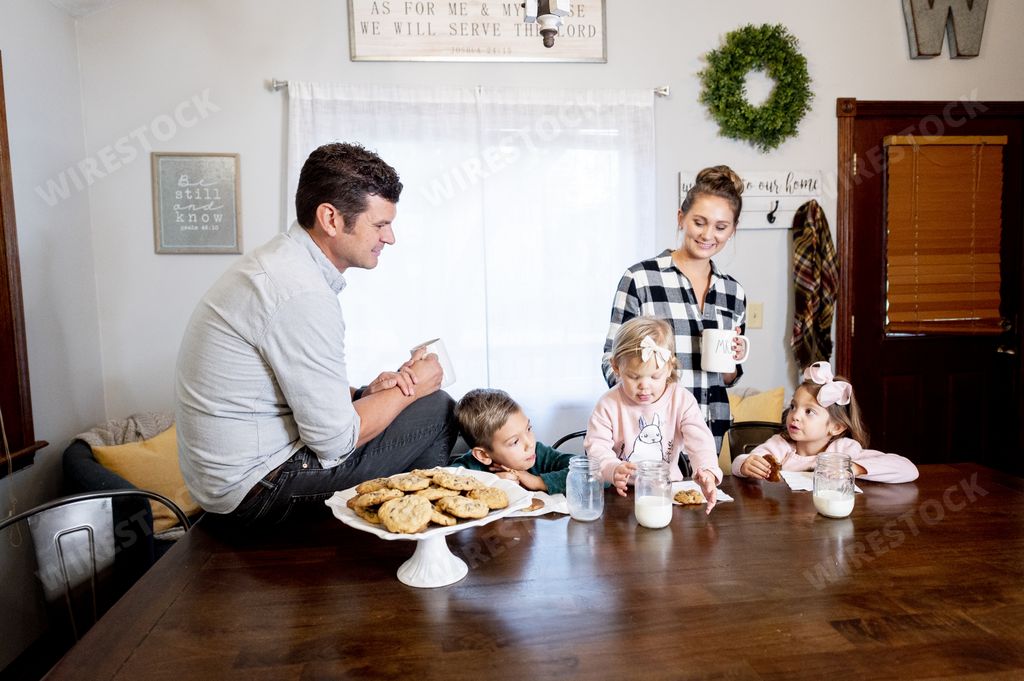 A closeup shot of a happy family eating chocolate chips and drinking milk - family concept