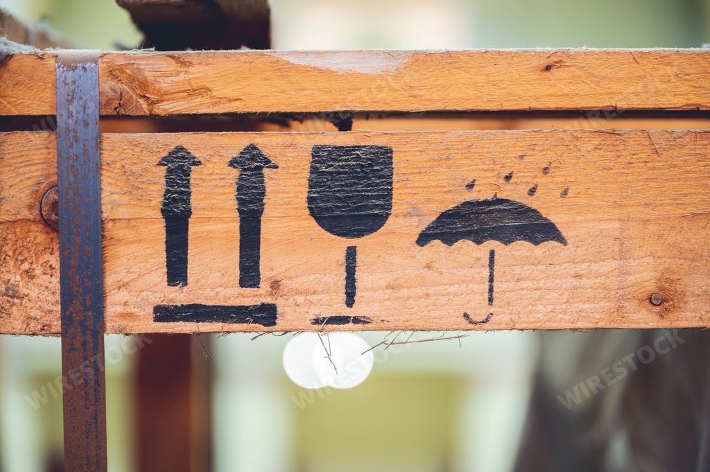 A closeup of the fragile symbol on a wooden signboard