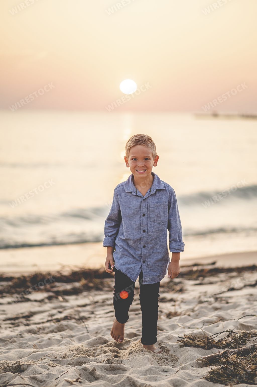 A shallow focus shot of a small blond boy on the beach