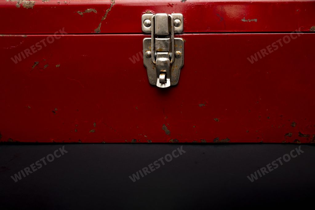 A closeup of a red metal vintage suitcase
