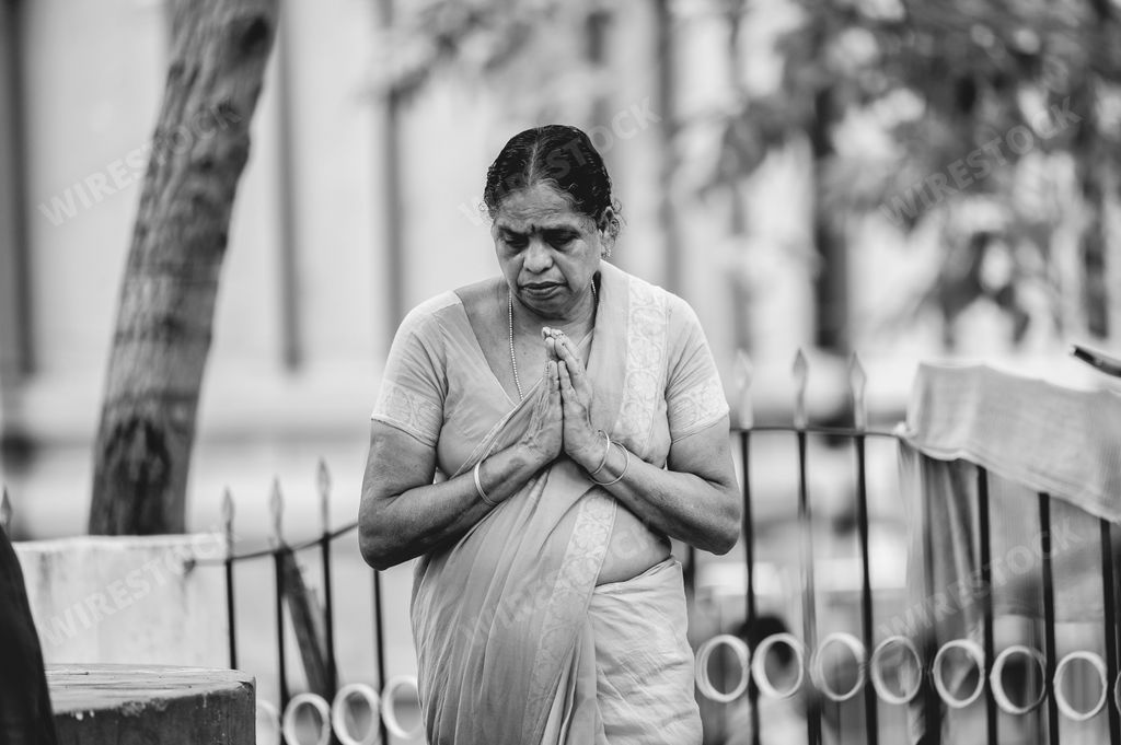 A grayscale of a woman praying to idols and guards at the Narasimha Hindu temple in Visakhapatnam India