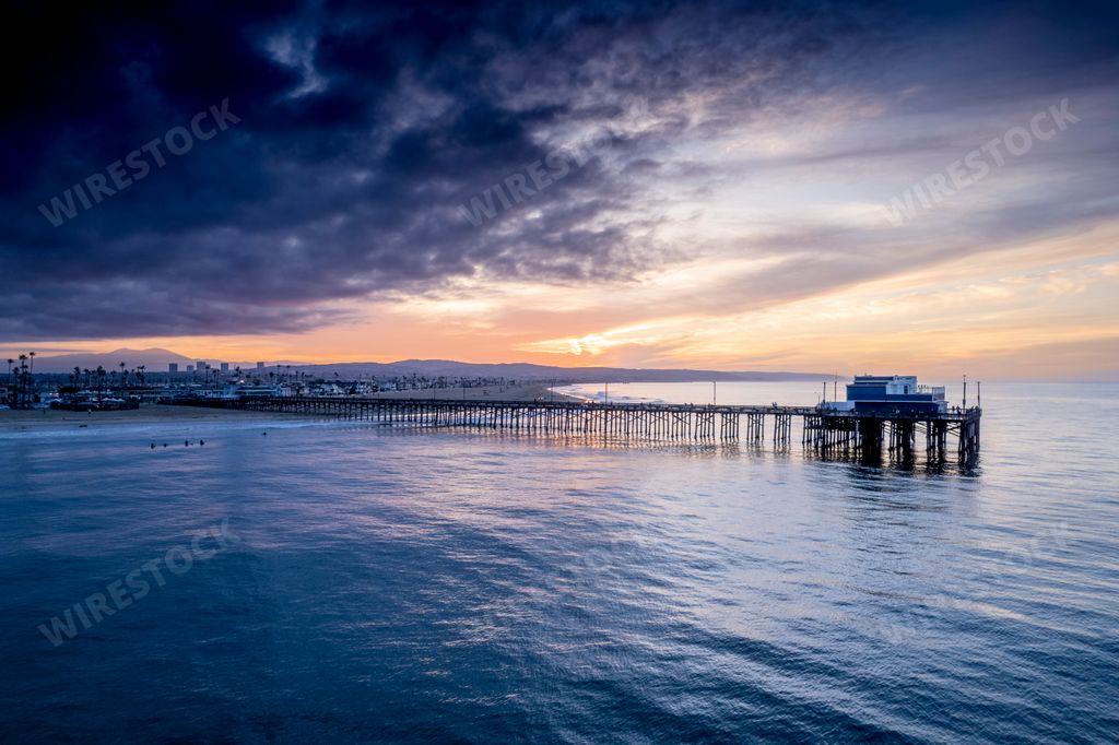 An aerial view of a long bridge in Newport Beach, California at sunset