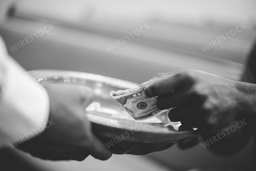 A closeup shot of a male donation to the church with blurred background in black and white